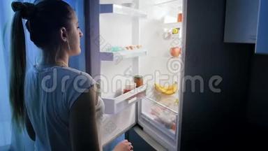 帕贾姆斯的年轻女子晚上<strong>打开冰箱</strong>，寻找食物