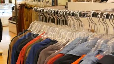 商场或购物中心的服装店里挂在衣架上的各种多色服装