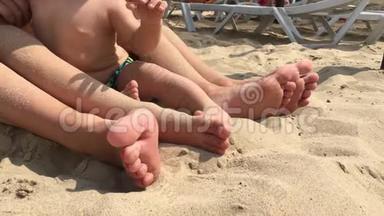 暑假，快乐的脚踩沙滩.. 在阳光明媚的夏日在海滩上放松的双脚特写。