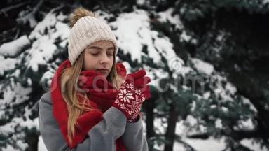 年轻漂亮的女孩穿着<strong>温暖</strong>的衣服站在圣诞树和<strong>温暖</strong>的手附近。 慢动作。 肖像