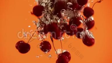 红色樱桃浆果的特写镜头：樱桃在橙色背景下落入水中