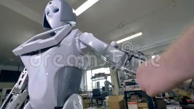一位工程师把白色外壳贴在机器人手臂上。