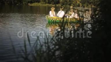 <strong>三个女孩</strong>和一<strong>个</strong>男人穿着斯拉夫民族服装漂浮在船上。 穿花环的<strong>女孩</strong>坐在船上。 民族传统