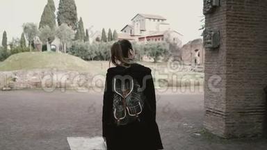 漂亮的年轻女孩正在意大利罗马四处走动，看着一件古董。 游客正在探索古老的废墟。