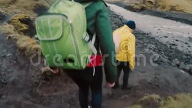 一群带背包的年轻人一起去野营。 朋友在河边的岩石上散步。