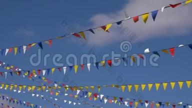 五颜六色的三角旗，在蓝天背景下迎风飘扬。 背景板，彩色关键视频