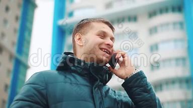 年轻的城市男子冬季商人专业的智能手机在街上行走使用应用程序短信信息。 关于