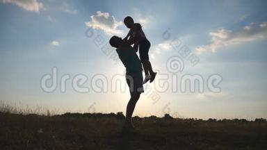 快乐的爸爸抛弃了他的小男孩。 日落时分，父亲和儿子在田野上玩耍。 爸爸和孩子一起玩