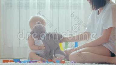<strong>快</strong>乐的妈妈和<strong>宝宝</strong>在家里地毯上玩玩具。 侧面看一对<strong>快</strong>乐的母子玩玩具