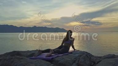 无人机显示女孩躺在瑜伽姿势对抗日出反射