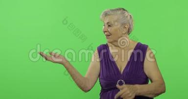 一位老妇人指着某物微笑。 老奶奶。 铬键