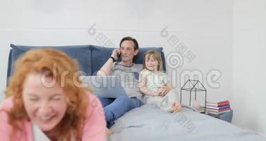 在卧室里，母亲和儿子用平板电脑拥抱父亲和达赫