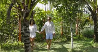 情侣牵手在热带花园拥抱和亲吻，快乐男人和女人<strong>出门</strong>