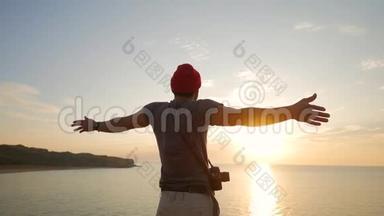年轻的摄影师游客站在悬崖上，挥舞着手臂面对金色的日落。 高清慢速运动。 克里米亚、俄罗斯