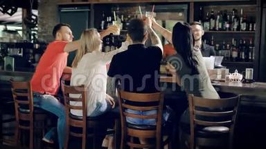 一群朋友在餐厅<strong>庆祝</strong>生日聚会，他们用鸡尾酒<strong>碰杯</strong>。 坐在那儿的人
