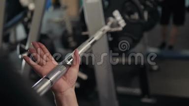 一个强壮的男人的双手`<strong>滑石粉</strong>，准备在车库健身房举重。 室内宏观