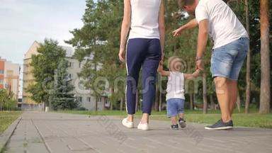 爸爸和妈妈和儿子牵着手在公园里。 家人在公园散步。