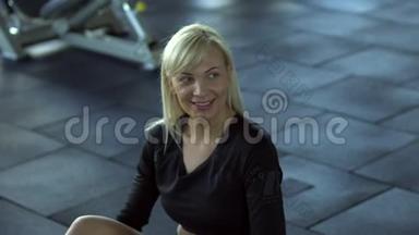 年轻女子在健身房锻炼期间休息