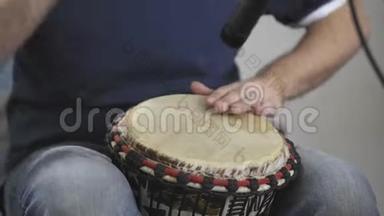 关闭音乐家在家庭音乐工作室演奏djembe鼓乐器。