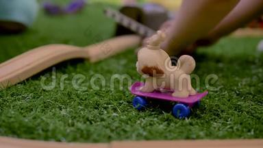 <strong>小朋友的</strong>手在房间里<strong>的</strong>紫色滑板上玩塑料玩具狗。