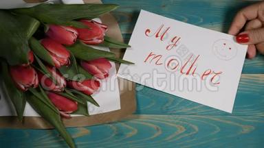 我母亲留言条和郁金香花束在木桌上的俯视图。 恋爱关系的概念。 母亲日