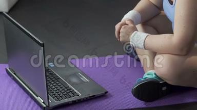 女孩坐在地板<strong>上</strong>，紧张地看着笔记本电脑<strong>上</strong>的视频，重新装<strong>上</strong>手表