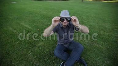 戴帽子的男人在夏日草地上戴太阳镜