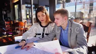 建筑师学生在咖啡馆的桌子上做联合草稿。