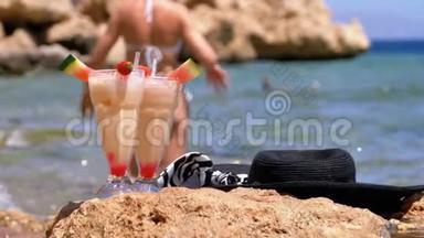 埃及海滩上的热带<strong>鲜榨果汁</strong>、帽子和眼镜架在红海边的岩石上