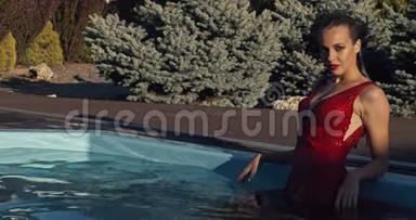 一位身穿红色连衣裙、化妆和湿发的年轻女子正在游泳池里摆姿势，4K