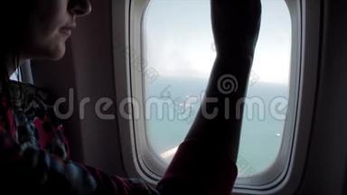 女人打开飞机窗户，在空中旅行时向外看。 很开心。 一起坐飞机旅行的女孩。 旅游概念