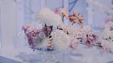 蓝色背景下水晶花瓶中婚礼花束的中间特写镜头