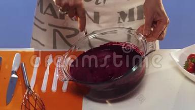 紫罗兰色的物质在大圆形<strong>玻璃</strong>锅里被人用手搅拌