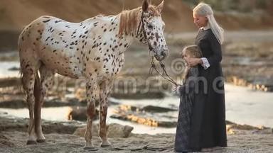 马疗法-河马疗法。 女人带着女儿和斑驳的马