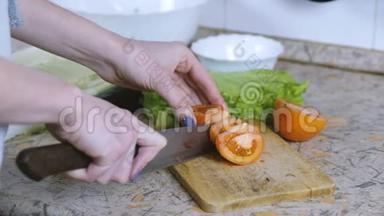 特写镜头中的女人用手把西红柿切成小块放在餐桌上的砧板上。慢动作。