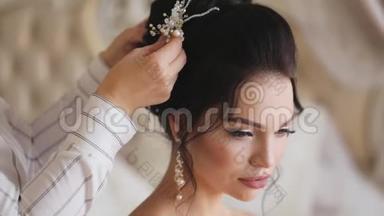 在婚礼那天，发型师为漂亮的年轻新娘整理了一个发型。