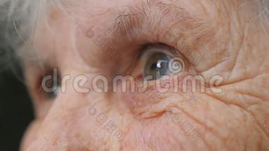 老妇人望着远处。 一位有<strong>皱纹</strong>的老太太的<strong>眼睛</strong>。 奶奶的特写肖像