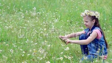 小女孩拿着手机，拿着手机，给他们拍照，拍着一块樟脑草坪