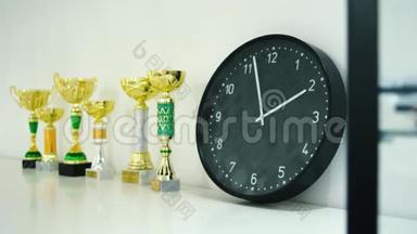 奖杯奖为获奖者在货架上展示。 库存。 架子上的时钟和奖杯.. 时间和运动的概念