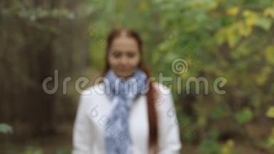 金发白种人中年妇女穿着白大褂在秋天公园的阴天散步