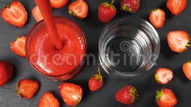 新鲜的草莓<strong>冰</strong>沙<strong>在玻璃杯中</strong>流动，准备饮用