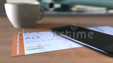 在前往德国的途中，在机场的桌子上放置汉堡和智能手机的登机牌