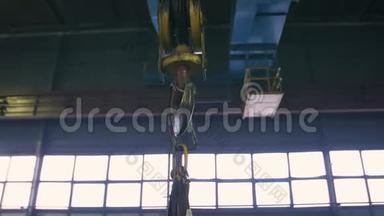 工业室内<strong>起重机吊钩</strong>在钢轨上。 绕着飞龙飞