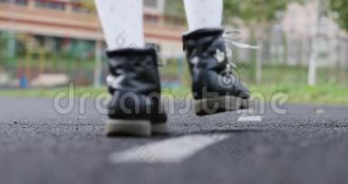 一个穿着白色连裤袜和黑色鞋子的小女生去上学。