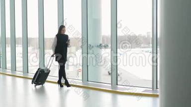 通勤车上的女商人在火车站或飞机上拿着手提行李走路时，在智能手机上讲话