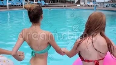 盛夏时节，后景朋友们手牵手跳着蓝色的水走进游泳池，欢乐的女孩