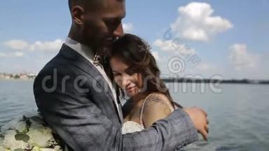 一对年轻漂亮的新婚夫妇站在湖边。 <strong>结婚纪念日</strong>。 慢动作