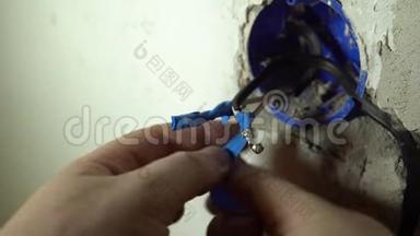 手的特写用<strong>蓝色胶带</strong>隔离焊接的电线。