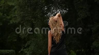 自然背景下金发女人的背景。 美丽的<strong>女孩</strong>摆着飞舞的头发。 慢动作