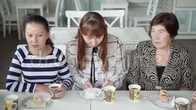 一支友好的女队在咖啡馆喝杯茶。 那个女孩正在吃蛋糕。 美味的茶甜<strong>点</strong>。